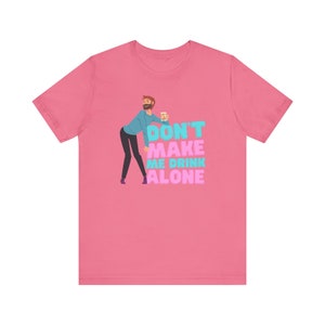 May include: Pink t-shirt featuring a cartoon illustration of a person holding a beer and the text "Don't make me drink alone".