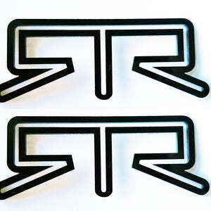 May include: Two black and white acrylic letter R's with a white outline. The letter R's are stacked on top of each other.