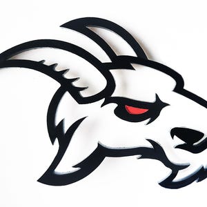 May include: Black and white silhouette of a goat's head with a red eye. The goat's head is facing the right side of the image. The goat's horns are curved and point upwards.