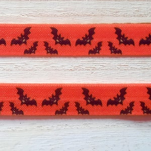 Diadema para implante coclear con murciélagos naranja y negro