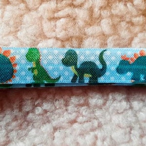 Diadema con implante coclear de dinosaurio