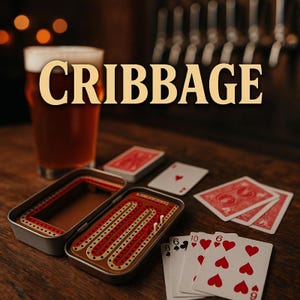 May include: A cribbage board game set with playing cards and a pint of beer. The cribbage board is in a metal case, with red and white pegs. The cards are red and white, with some face up. The word "CRIBBAGE" is in gold letters.