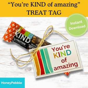 May include: A KIND peanut butter protein bar tied with twine to a rectangular tag. The tag reads "You're KIND of amazing" with colorful stripes. A green circle with "Instant Download" is also visible.