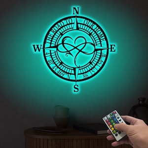 May include: A black metal compass with the words "The Road To Our Home" around the edge. The compass has a heart-shaped design in the center and a remote control for changing the color of the light.