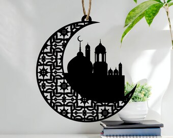 May include: Black silhouette of a mosque inside a crescent moon with intricate geometric patterns. The ornament is made of wood and has a string for hanging.