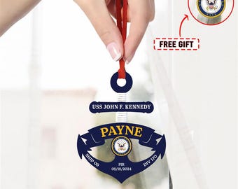 May include: A blue and white anchor-shaped ornament with the text "USS JOHN F. KENNEDY" and "PAYNE" on it. The ornament also includes the text "SHIP 09", "PIR 08/18/2024", and "DIV 170".