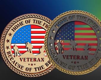 May include: Two wooden round plaques with a rope border. Both plaques feature an American flag with the words "Home of the Free" and "Because of the Brave" surrounding the flag. The text "Veteran" is centered below the flag with three stars below the word. The flag on the left plaque is red, white, and blue. The flag on the right plaque is blue, green, and red.