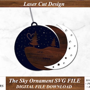 Peut inclure: Une décoration en bois découpée au laser représentant un croissant de lune avec des étoiles et un ciel bleu foncé avec un cœur et deux arbres. Le texte dit "Le ciel a l'air différent quand quelqu'un que vous aimez est là-haut".