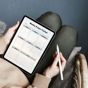 May include: A digital tablet displaying a weekly prayer tracker with a white stylus on a gray surface. The tracker has a grid with days of the week labeled: Monday, Tuesday, Wednesday, Thursday, Friday, Saturday, Sunday, and Notes.