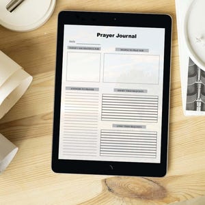 May include: A digital tablet displaying a printable prayer journal template with sections for date, things to be grateful for, people to pray for, answers to prayer, short-term requests, and long-term requests.