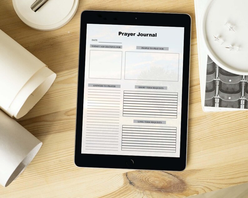 May include: A digital tablet displaying a printable prayer journal template with sections for date, things to be grateful for, people to pray for, answers to prayer, short-term requests, and long-term requests.