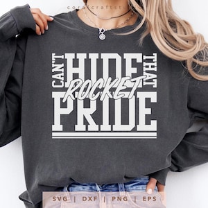 May include: Dark gray long-sleeve sweatshirt with the text "Can't Hide That Rocket Pride" in white block letters. The design includes a horizontal line at the bottom. The sweatshirt is a casual style.
