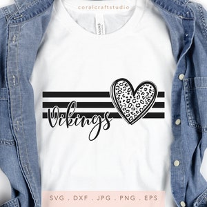 May include: A white t-shirt with black stripes and the word "Vikings" in a cursive font. A leopard print heart is centered above the word.