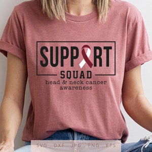 May include: A pink t-shirt with the text "SUPPORT SQUAD" in a black box. A white ribbon with a maroon outline is inside the box. The text "head & neck cancer awareness" is below the box.
