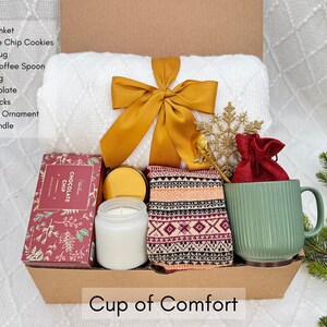 Holiday care package with mug, candle, socks and cozy blanket for winter self-care