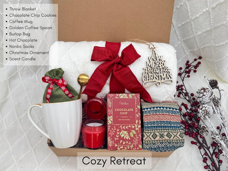 Puede incluir: Una caja de regalo "Cozy Retreat" contiene una manta blanca, galletas con chispas de chocolate, una taza de caf&eacute;, una cuchara dorada, una bolsa de arpillera, chocolate caliente, calcetines n&oacute;rdicos, un adorno navide&ntilde;o y una vela perfumada.