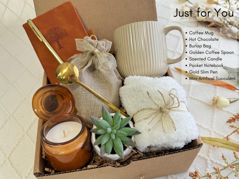 May include: A gift box filled with items for self-care and relaxation. The box includes a coffee mug, a candle, a small succulent, a notebook, a pen, a burlap bag, and a towel.