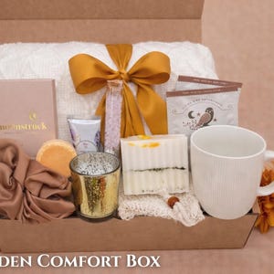 Spa gift box for women featuring luxury bath salts, a white candle, and a soft blanket.