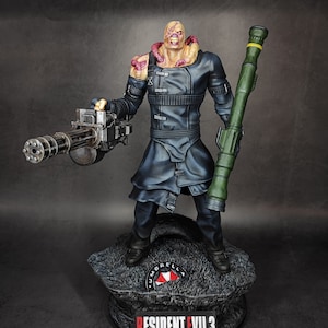 May include: A detailed action figure of a zombie-like character from the Resident Evil 3 video game. The figure is holding a large machine gun and a rocket launcher. The figure is standing on a black base with the words "Resident Evil 3" and the Umbrella Corporation logo.