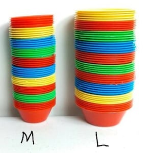 Peut inclure: Deux piles de gobelets en plastique colorés, l'un étiqueté 'M' et l'autre 'L'. Les gobelets sont rouges, jaunes, bleus et verts.