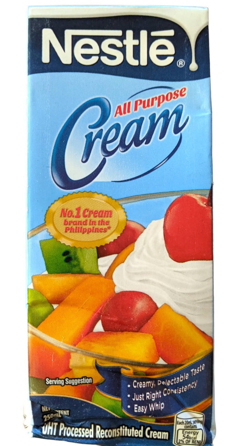 Puede incluir: Una caja azul y blanca de Nestle All Purpose Cream. La caja presenta una sugerencia de servicio de ensalada de frutas cubierta con crema batida. El texto "No. 1 Cream brand in the Philippines" est&aacute; en un sello dorado. La caja es de 250 ml y es crema reconstituida procesada UHT.