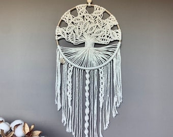 Op de afbeelding: Witte macramé droomvanger met een levensboomontwerp en witte kralen die aan de onderkant hangen.