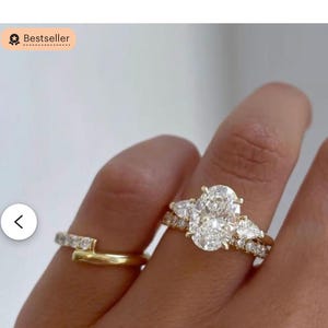 2 karaat ovale diamanten verlovingsring met drie stenen• 14k geelgouden trilogiering• Peer aan de zijkant• Ovale moissanietring• Jubileumring