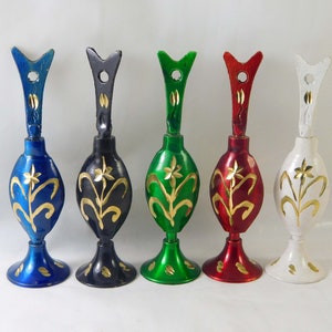 Op de afbeelding: Vijf decoratieve metalen flessen met gouden bloemmotieven. De flessen zijn in blauw, zwart, groen, rood en wit.