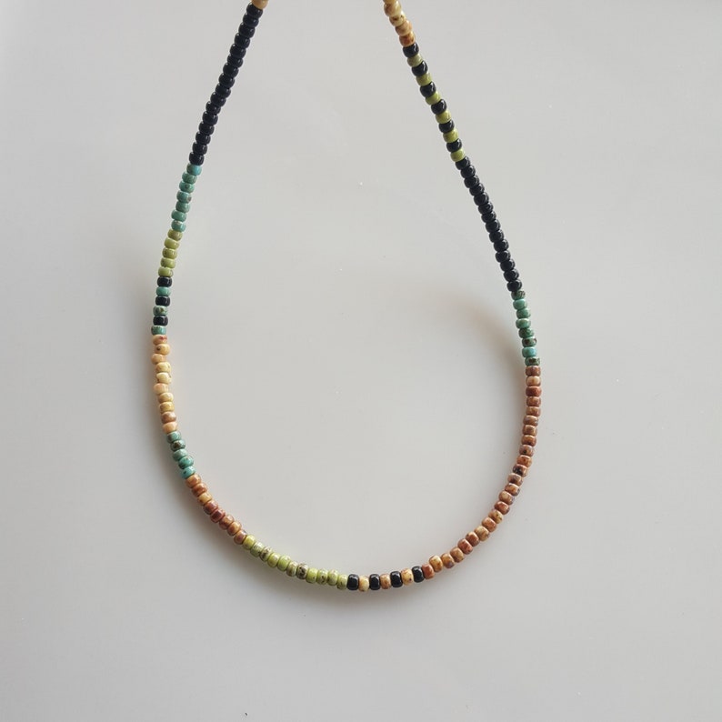 May include: A multi-coloured beaded necklace with black, brown, green and turquoise beads.