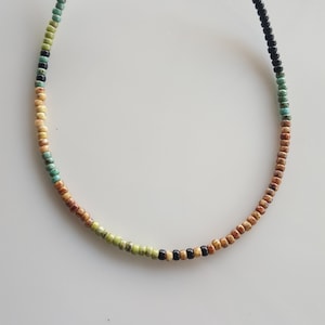May include: A multi-coloured beaded necklace with brown, black, green and turquoise beads.