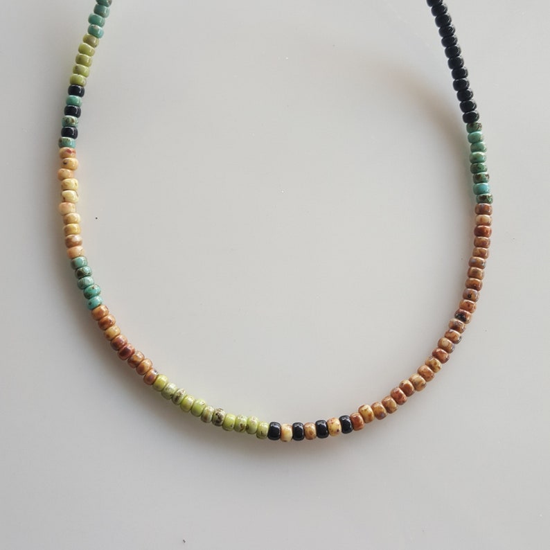 May include: A multi-coloured beaded necklace with brown, black, green and turquoise beads.