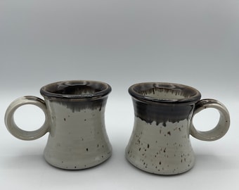 Set of 2 glazed speckled stoneware mugs marked Clay in Mind San Diego CA white, brown & off white