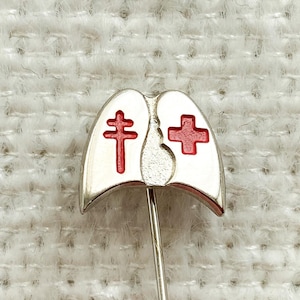 Può includere: Spilla d'argento a forma di polmoni con una croce rossa su ogni lato.