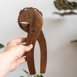 May include: A wooden nutcracker with intricate carvings. The nutcracker is brown and has a traditional design.