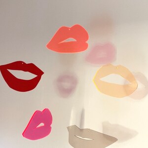 Pu&ograve; includere: Un mobile con cinque labbra di diversi colori, ognuna con una forma e una dimensione uniche. Le labbra sono realizzate in un materiale leggero e sono sospese da una corda sottile. Il mobile &egrave; una decorazione divertente e fantasiosa per una cameretta o una casa moderna.