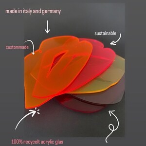 Pu&ograve; includere: Pila di quattro lettere in acrilico traslucido e colorato, realizzate in vetro acrilico riciclato. Le lettere sono in varie tonalit&agrave; di arancione, rosso, giallo e viola. Le lettere sono realizzate in Italia e Germania e sono descritte come sostenibili, personalizzate e realizzate per essere miscelate e abbinate.