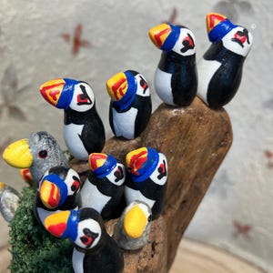 Unusual, handmade colony of 13 puffins on a gorgeous, leaning driftwood block.