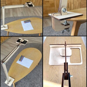 May include: A wooden phone stand with a clamp that can be attached to a table or desk. The stand has a phone holder and a small shelf for holding pencils or other items. The stand is made of natural wood and has a simple, modern design.
