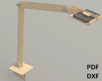 Op de afbeelding: Een houten bureaulamp met een lange, scharnierende arm en een rechthoekige basis. De lamp is ontworpen om een tablet of telefoon te houden.