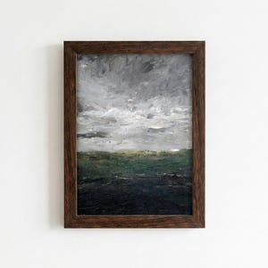 Puede incluir: Pintura de paisaje enmarcada en un marco de madera marrón oscuro. La obra de arte representa un cielo nublado sobre un paisaje verde oscuro y negro. La pintura utiliza pinceladas gruesas para crear textura y profundidad.