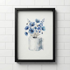 May include: A framed watercolour print depicts a roll of white toilet paper with a bouquet of blue flowers. The flowers are in varying shades of blue, and the artwork is set against a white background. The frame is black.