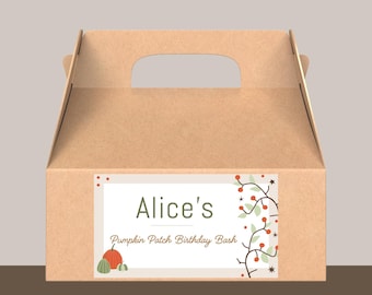 May include: A brown cardboard gift box with a handle cut-out. The box features a label with the text "Alice's Pumpkin Patch Birthday Bash", along with illustrations of pumpkins and fall foliage. The box is designed for a birthday celebration.