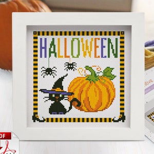May include: Cross stitch pattern featuring a black cat wearing a witch's hat, a pumpkin, and spiders. The text "HALLOWEEN" is in the center of the design.