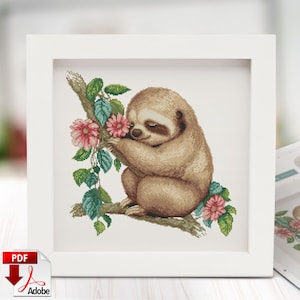 Puede incluir: Un patrón de punto de cruz con un perezoso marrón con flores rosas y hojas verdes. El perezoso está sentado en una rama y parece estar oliendo las flores.