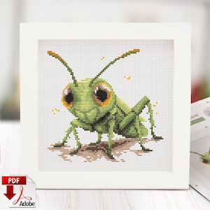 May include: Cross-stitch art of a cartoon grasshopper with large brown eyes and green body. The grasshopper is on a brown surface, set against a white background within a white frame. The PDF Adobe logo is in the lower left corner.
