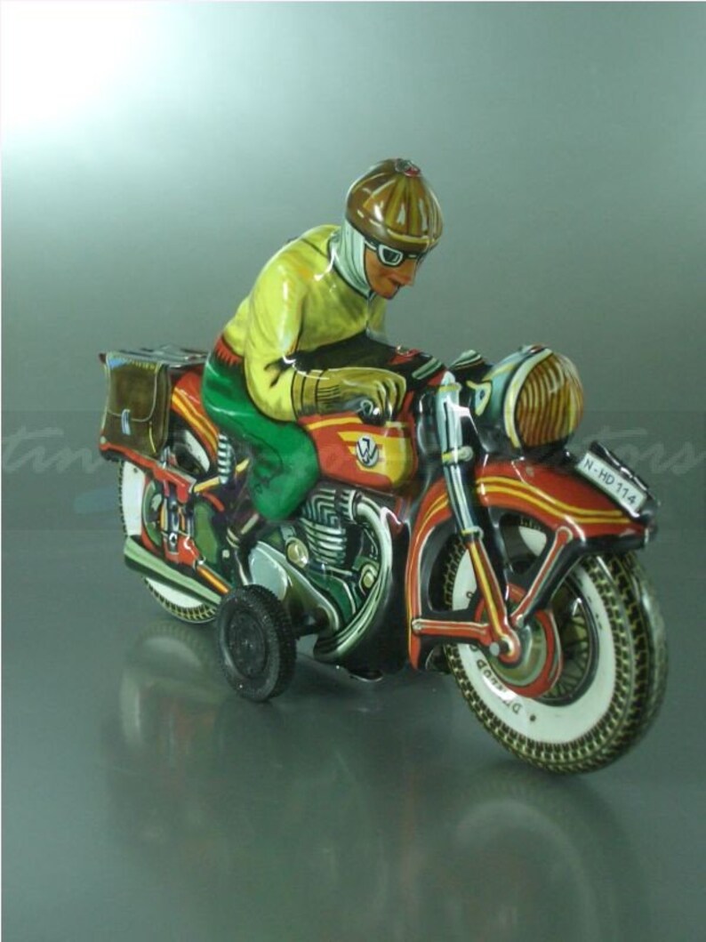 K&ouml;nnte beinhalten: Ein rotes, gelbes und gr&uuml;nes Spielzeugmotorrad mit einem Fahrer, der einen Helm und eine Schutzbrille tr&auml;gt. Das Motorrad hat einen Beiwagen und ein Nummernschild mit der Aufschrift "N-HD 714".