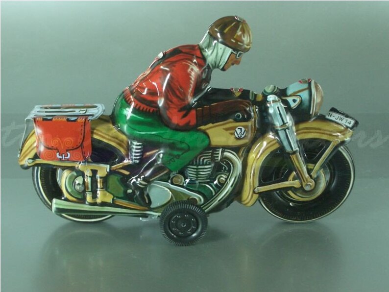 K&ouml;nnte beinhalten: Ein Vintage-Blechspielzeug-Motorrad mit einem Fahrer in einer roten Jacke und gr&uuml;nen Hosen. Das Motorrad ist braun und goldfarben mit schwarzen R&auml;dern und einem Beiwagen. Das Motorrad hat ein Nummernschild mit der Aufschrift "N-JW 14".