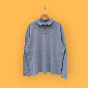 May include: A grey long-sleeved polo shirt with a zip and a small embroidered logo on the left chest.