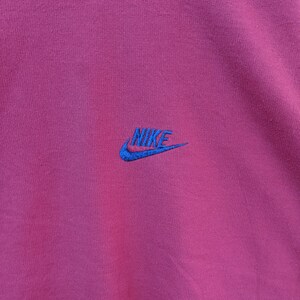May include: A maroon sweatshirt with a blue embroidered Nike logo.