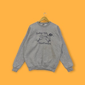 May include: A grey sweatshirt featuring a cartoon roadrunner wearing sunglasses and the text "Rolling Hills Roadrunners".